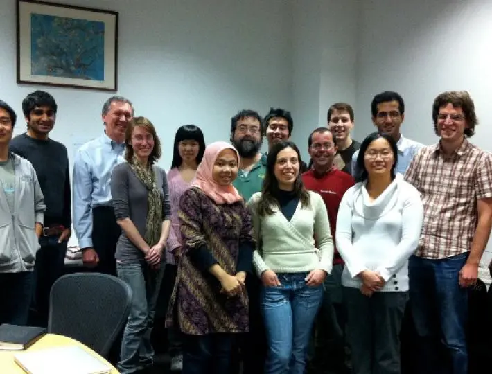 A group of men and women pose in a conference room.